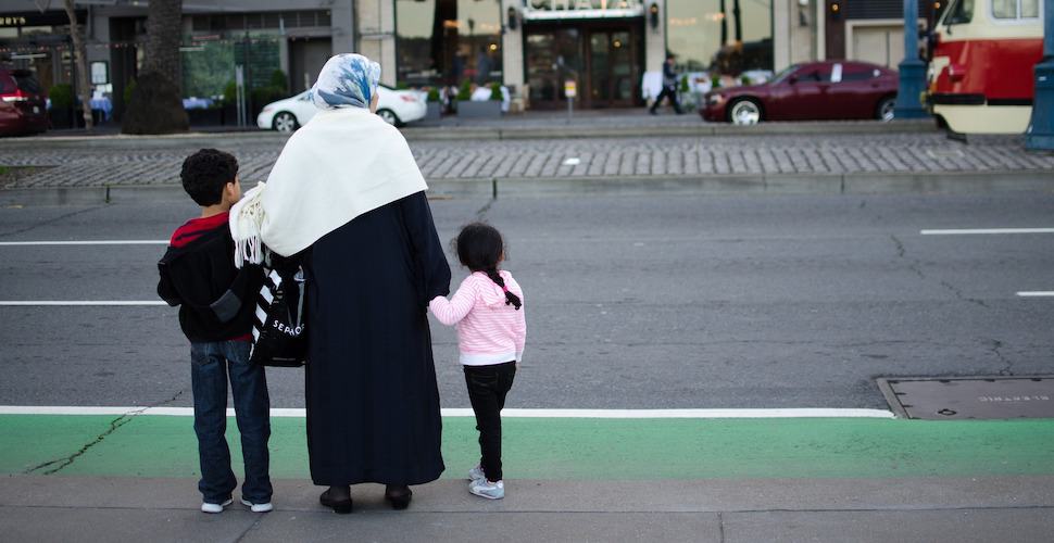 Migrant family crossing road