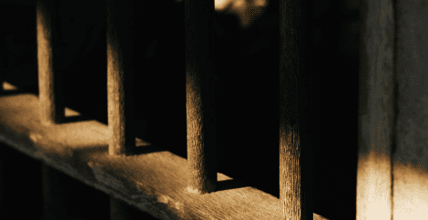 Dark jail cell bars in shadow