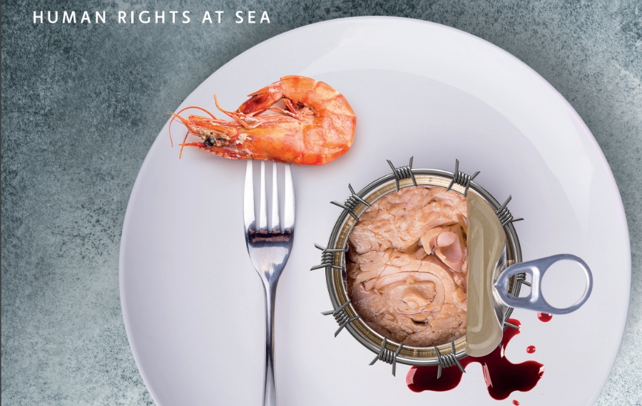 Gambero cotto su una forchetta appoggiato su un piatto bianco accanto a una scatola di tonno aperta circondata da filo spinato e gocce di sangue