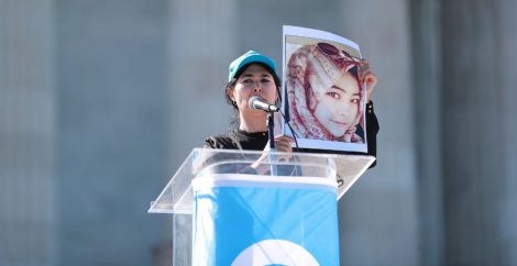 Attivista per i diritti degli uiguri in piedi sul podio