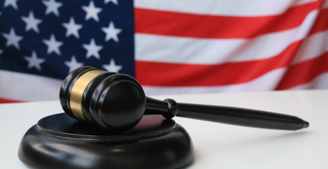 Wooden judicial hammer on table in front of U.S. flag
