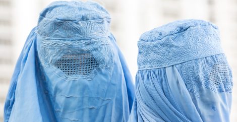Dos rostros de mujeres cubiertos por niqaabs de color azul claro.