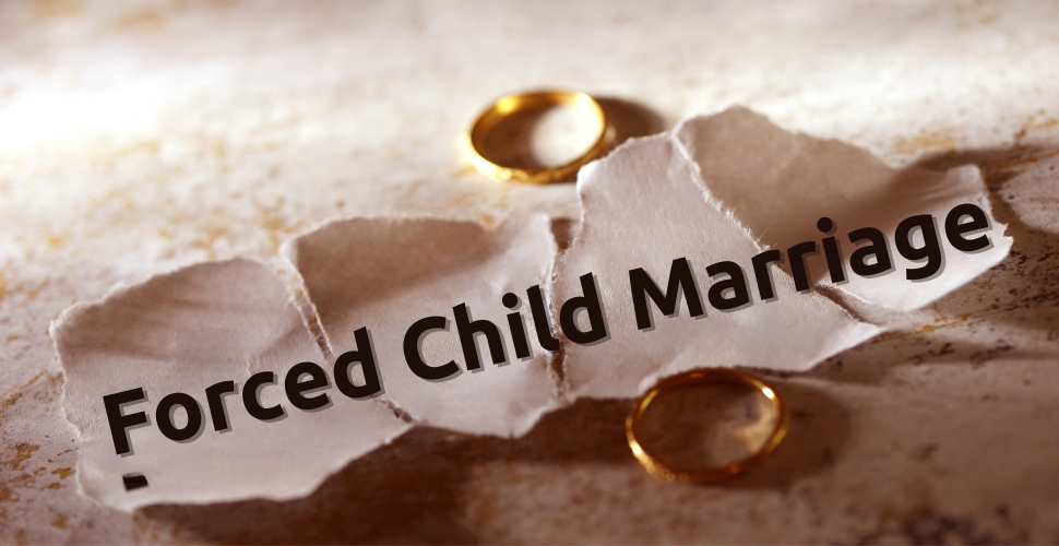 Forced child marriages written on a crumbled piece of paper with two rings next to it