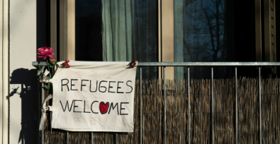 Cartel de bienvenida a los refugiados colgado en la terraza.
