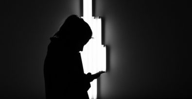 Serious silhouette of a young girl on phone