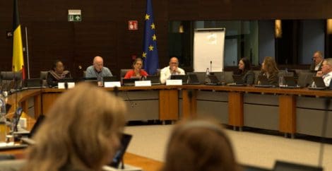 Eine Frau spricht bei einer Podiumsdiskussion in einem formellen Meeting in ein Mikrofon