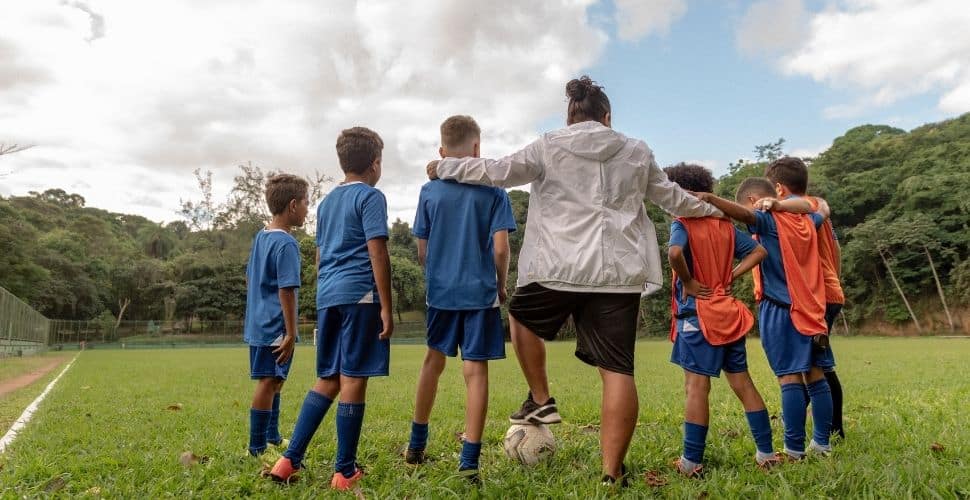 Young soccer players huddled with their coach