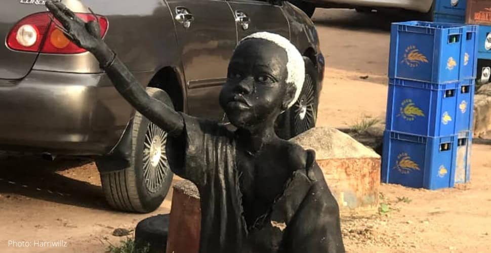 a sculptural representation of a child beggar