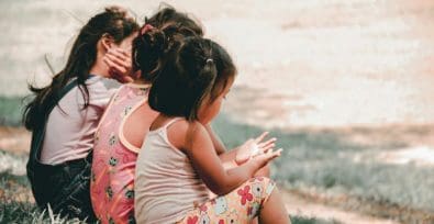 Kinder sitzen auf einem Hügel