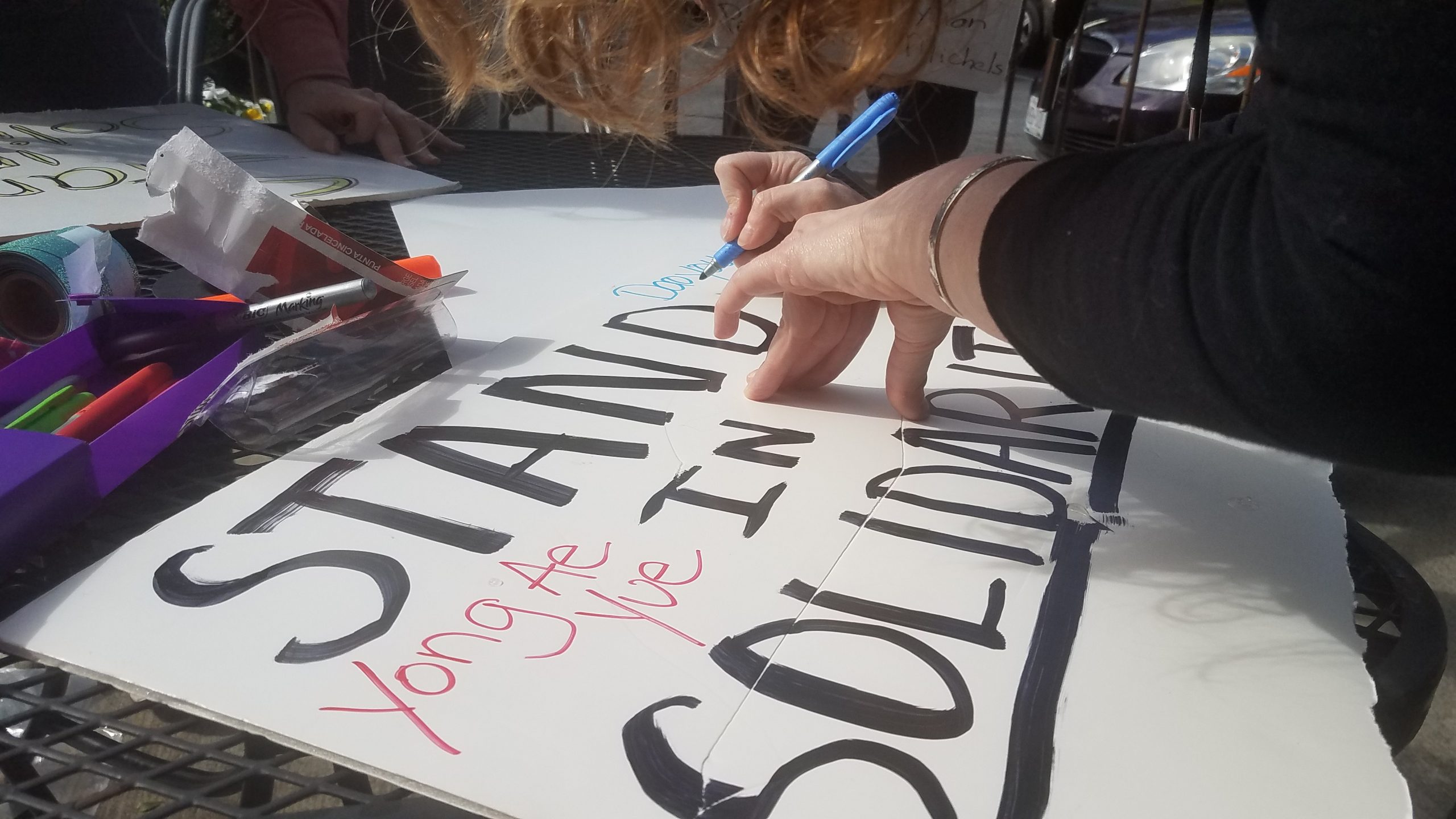 a woman hand writing a sign